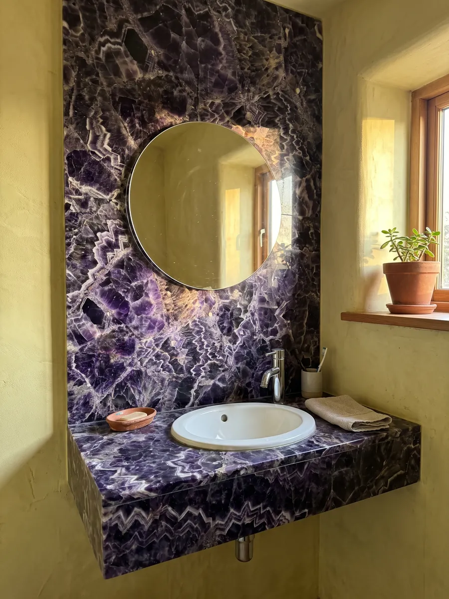Baño de visitas con pared y cubierta flotante de Amatista con espejo redondo: cristales violeta oscuro con franjas blancas y lilas en zigzag
