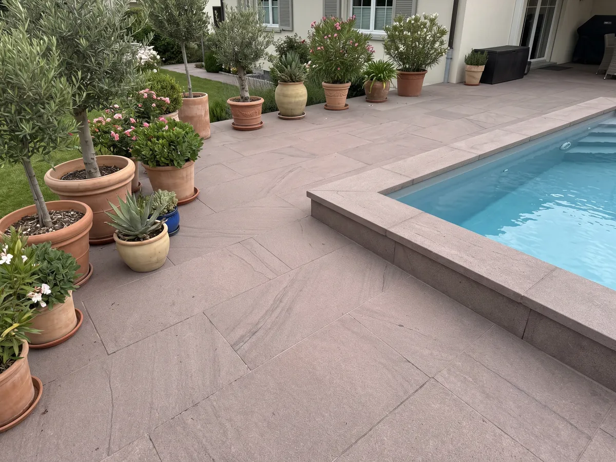 Piso de terraza y borde de piscina en Arenisca Santafiora Brown con macetas: superficie de grano fino color malva casi homogénea, sin vetas marcadas
