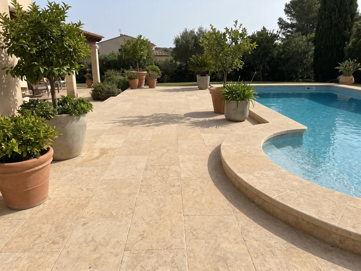 Piso de terraza y borde de piscina en Arenisca Santafiora Havana con macetas: tono crema cálido con nubes doradas difusas y textura arenosa suave
