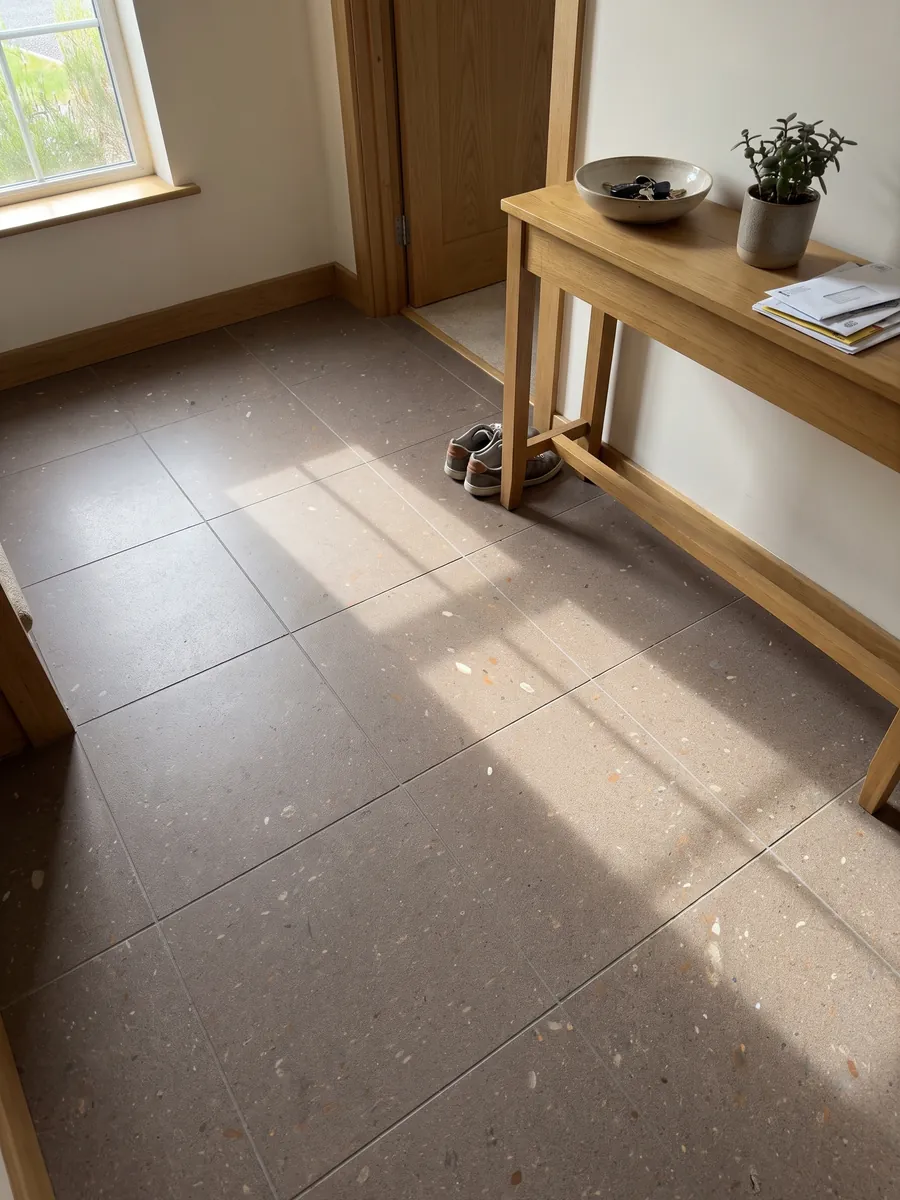 Piso de recibidor en placas grandes de Basalto Lavarosa con luz natural: tono topo rosado de grano fino con pequeñas inclusiones blancas y rojizas