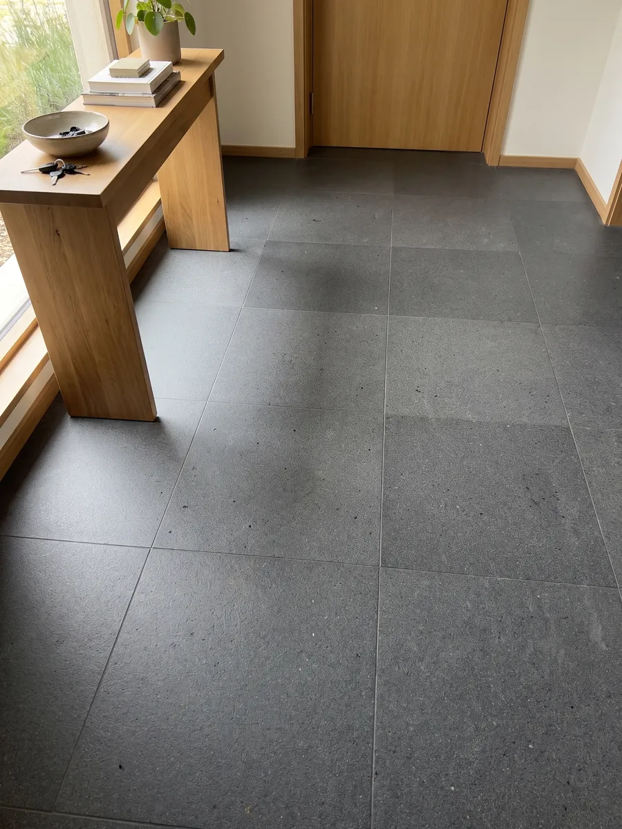 Piso de recibidor en placas grandes de Basalto Pietra Lavica con luz natural: gris casi negro, homogéneo y de grano muy fino