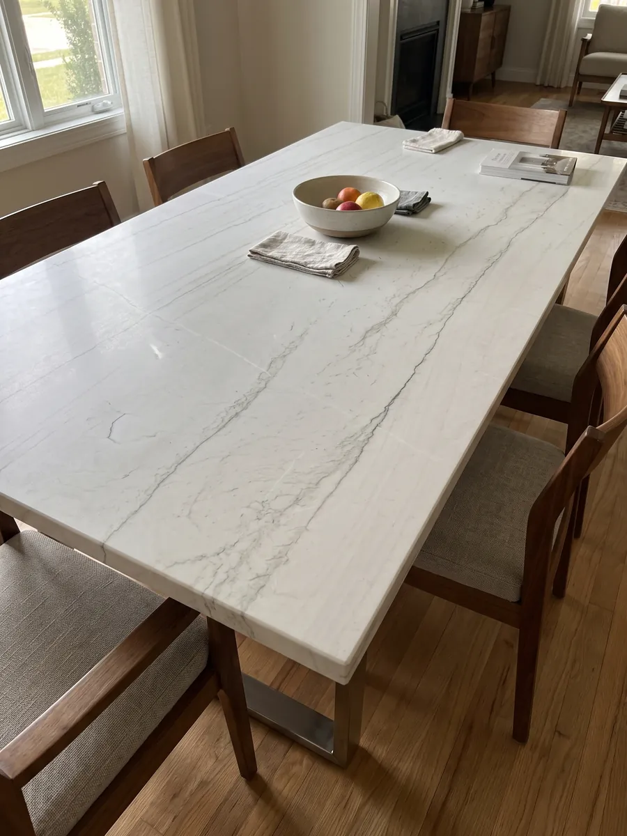 Mesa de comedor con cubierta de cuarcita blanca Mont Blanc sobre base de acero: blanco casi limpio con dos o tres líneas grises muy finas