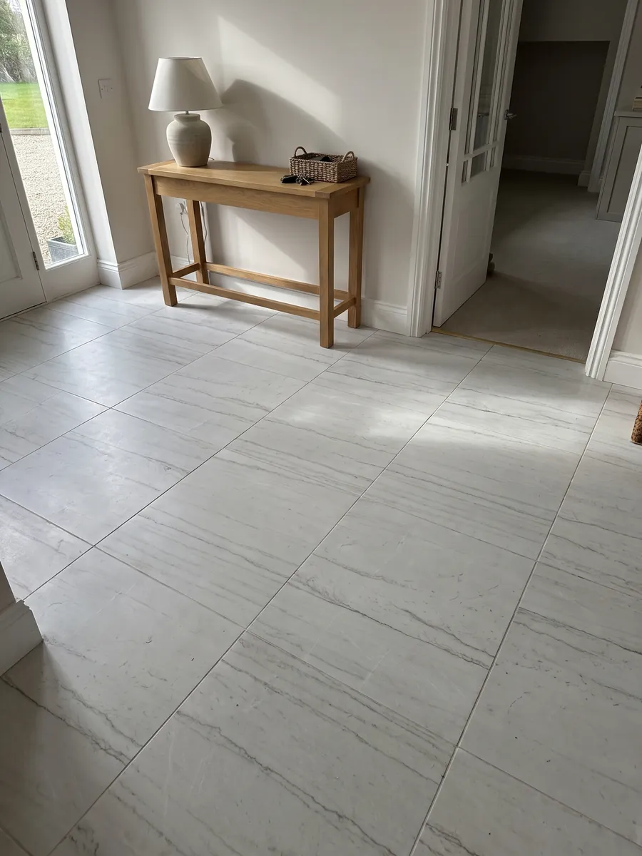 Piso de recibidor en placas grandes de cuarcita blanca Mont Blanc con luz natural: blanco casi limpio con dos o tres líneas grises muy finas