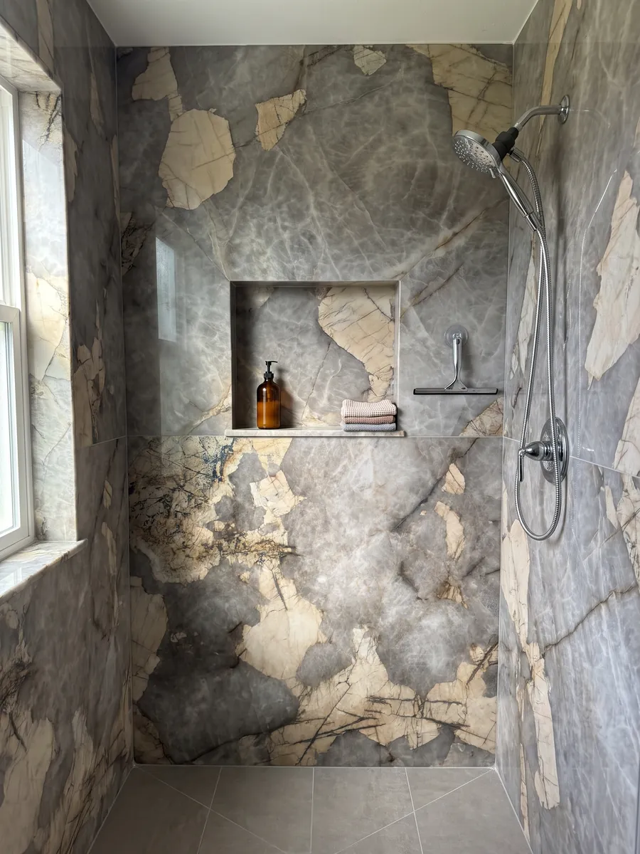 Ducha revestida con placas enteras de cuarcita gris Patagonia con nicho empotrado: gris nublado con grandes parches beige irregulares y finas líneas oscuras