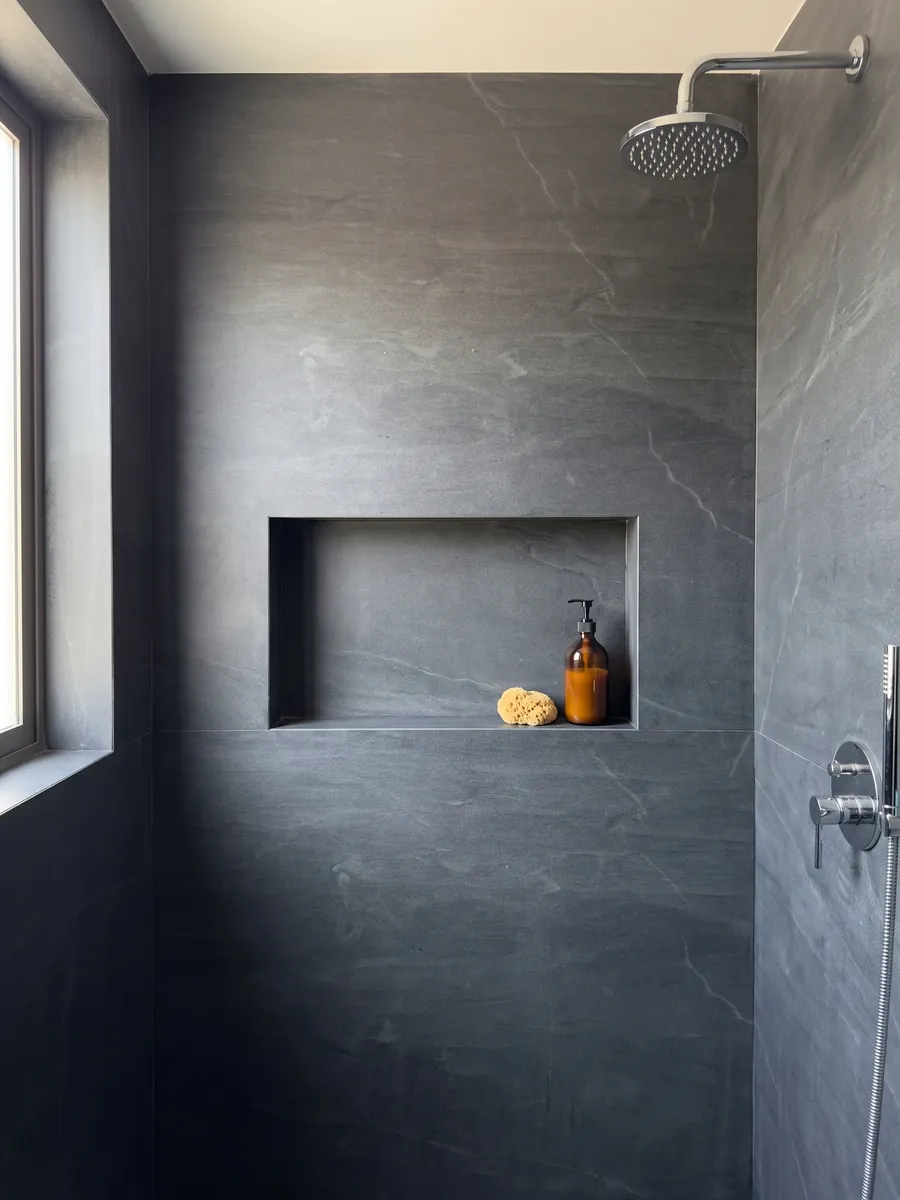 Ducha revestida con placas enteras de cuarcita gris Pietra del Cardoso con nicho empotrado: gris pizarra oscuro uniforme, sin dibujo