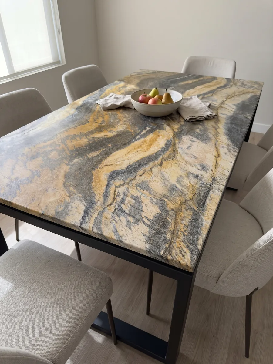 Mesa de comedor con cubierta de Cuarcita Jacaranda sobre base de acero: bandas onduladas amarillo mostaza y gris oscuro de mucho movimiento