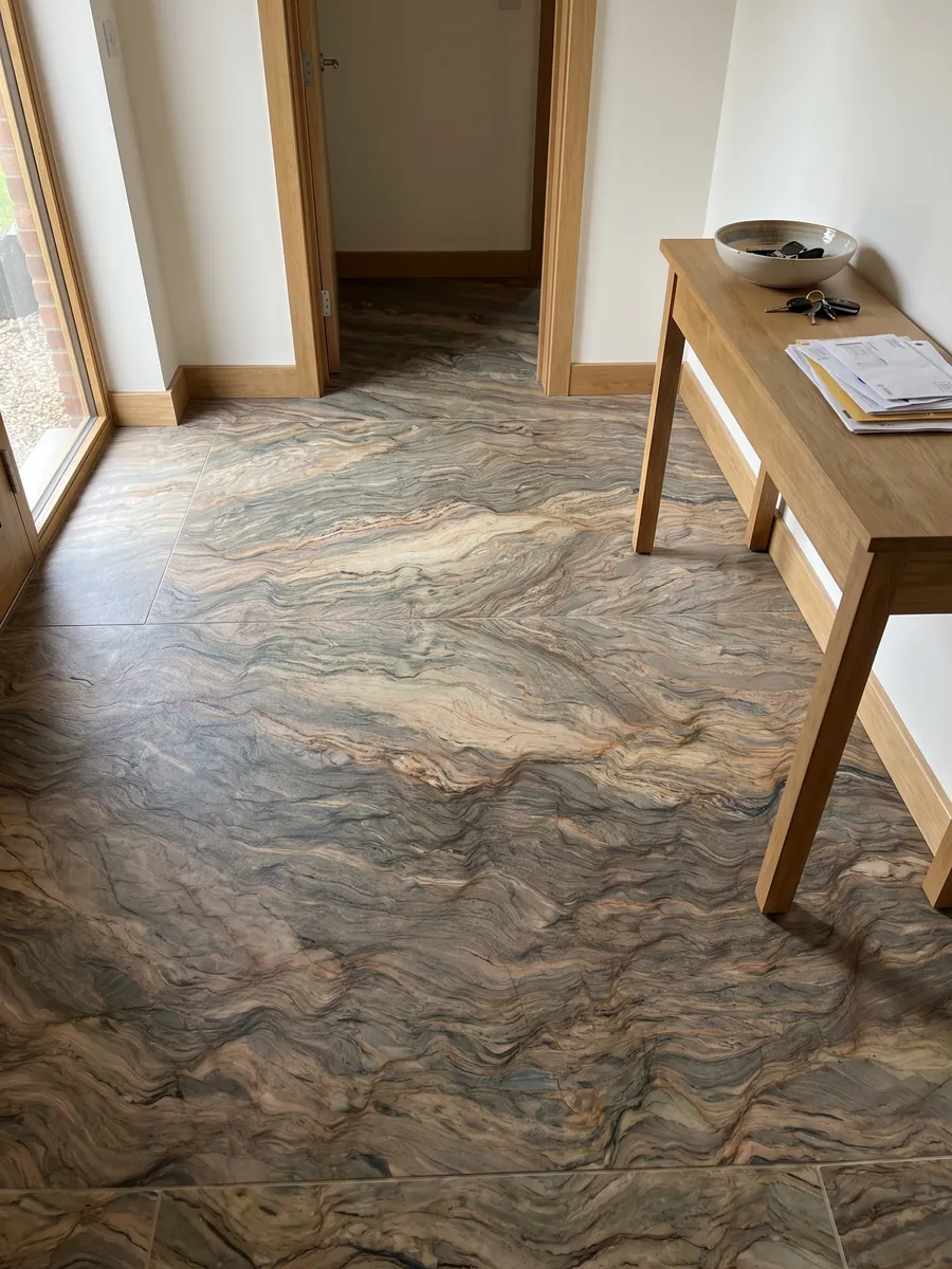 Piso de recibidor en placas grandes de cuarcita marrón Fusion con luz natural: ondas horizontales en ocre y gris verdoso, como capas de tierra