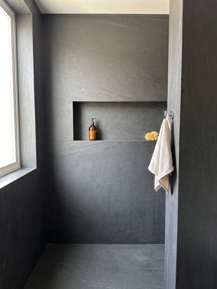 Ducha revestida con placas enteras de cuarcita negra Black Vermont con nicho empotrado: gris antracita casi uniforme, sin dibujo apreciable
