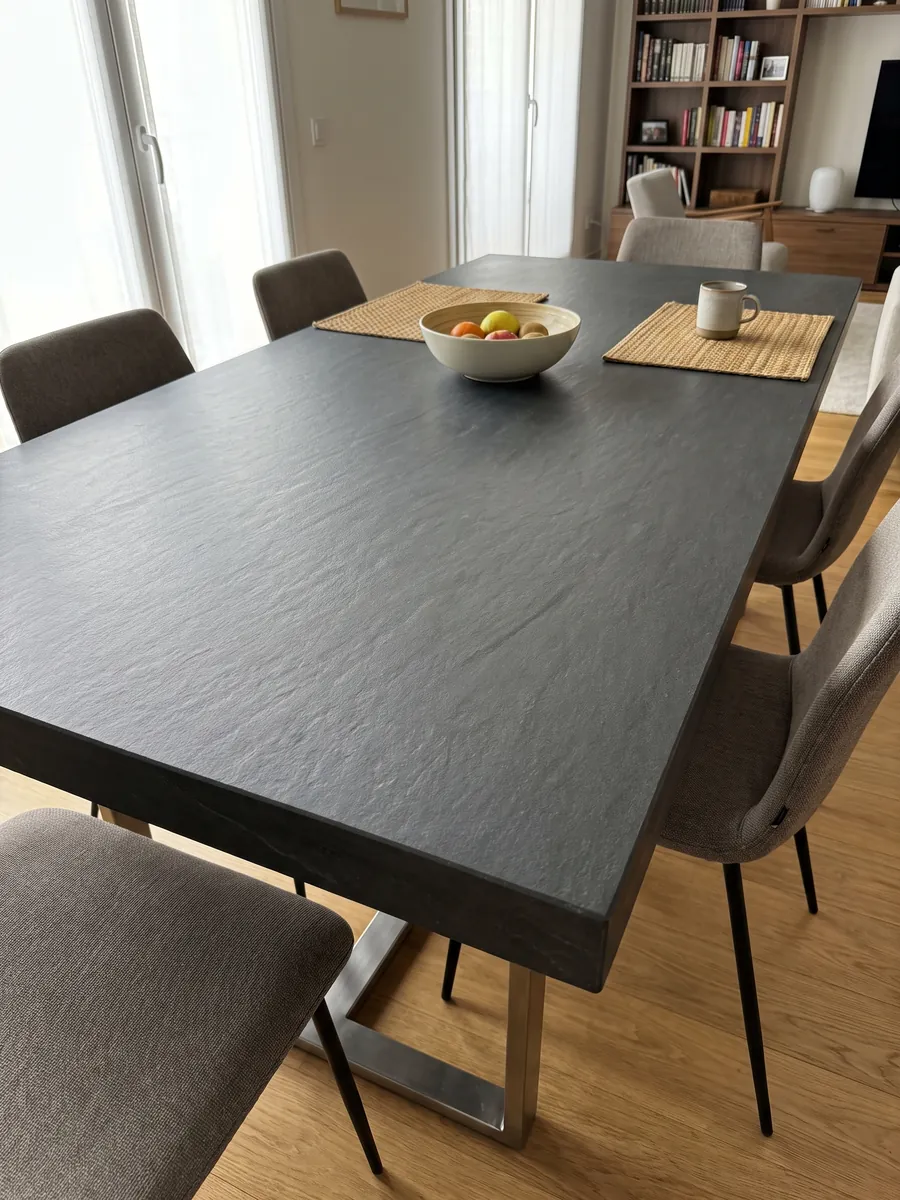Mesa de comedor con cubierta de cuarcita negra Black Vermont sobre base de acero: gris antracita casi uniforme, sin dibujo apreciable