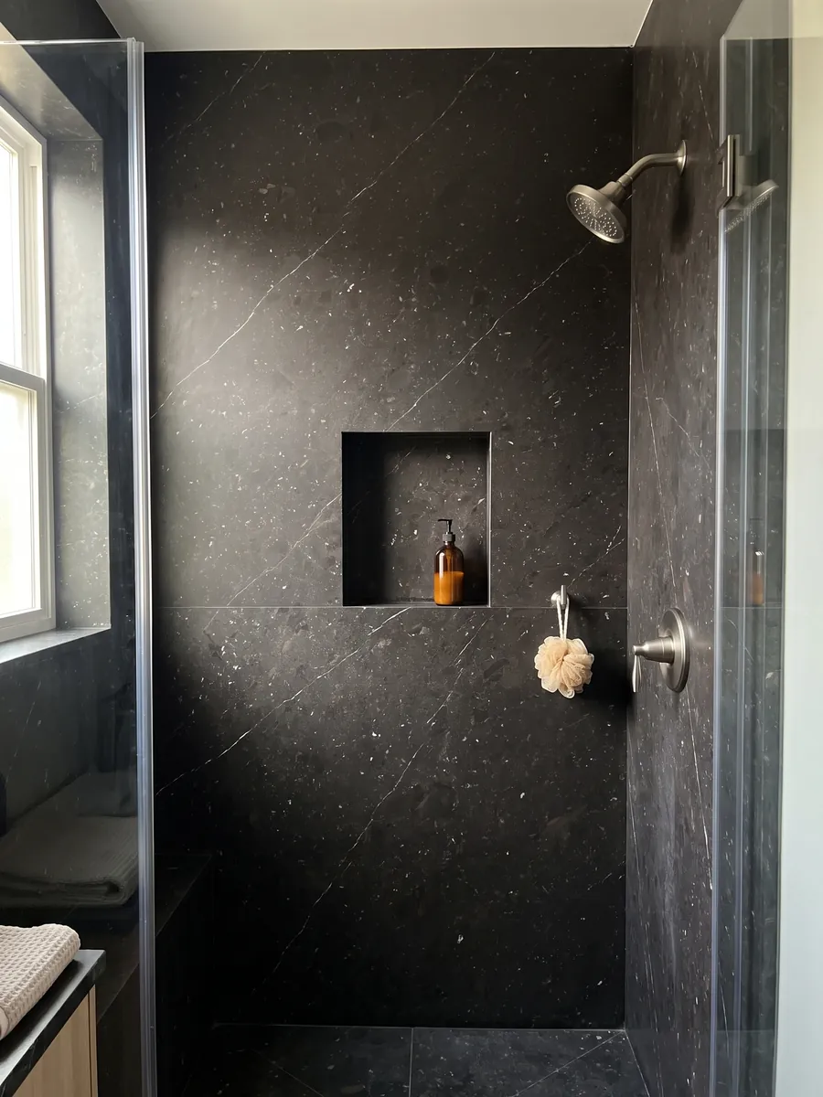 Ducha revestida con placas enteras de cuarcita negra Infinity Brown con nicho empotrado: casi negro con finas vetas blancas diagonales y motas claras