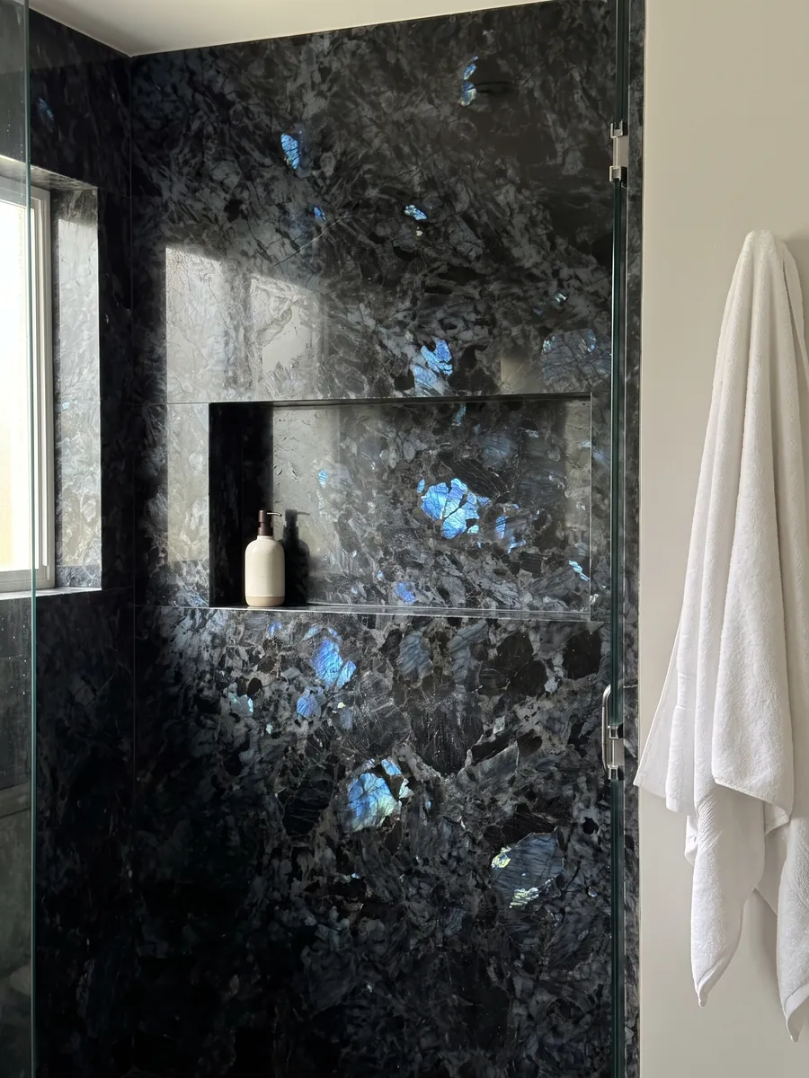 Ducha revestida con placas enteras de cuarcita negra Lemurian con nicho empotrado: negro de cristales grandes con destellos azul iridiscente