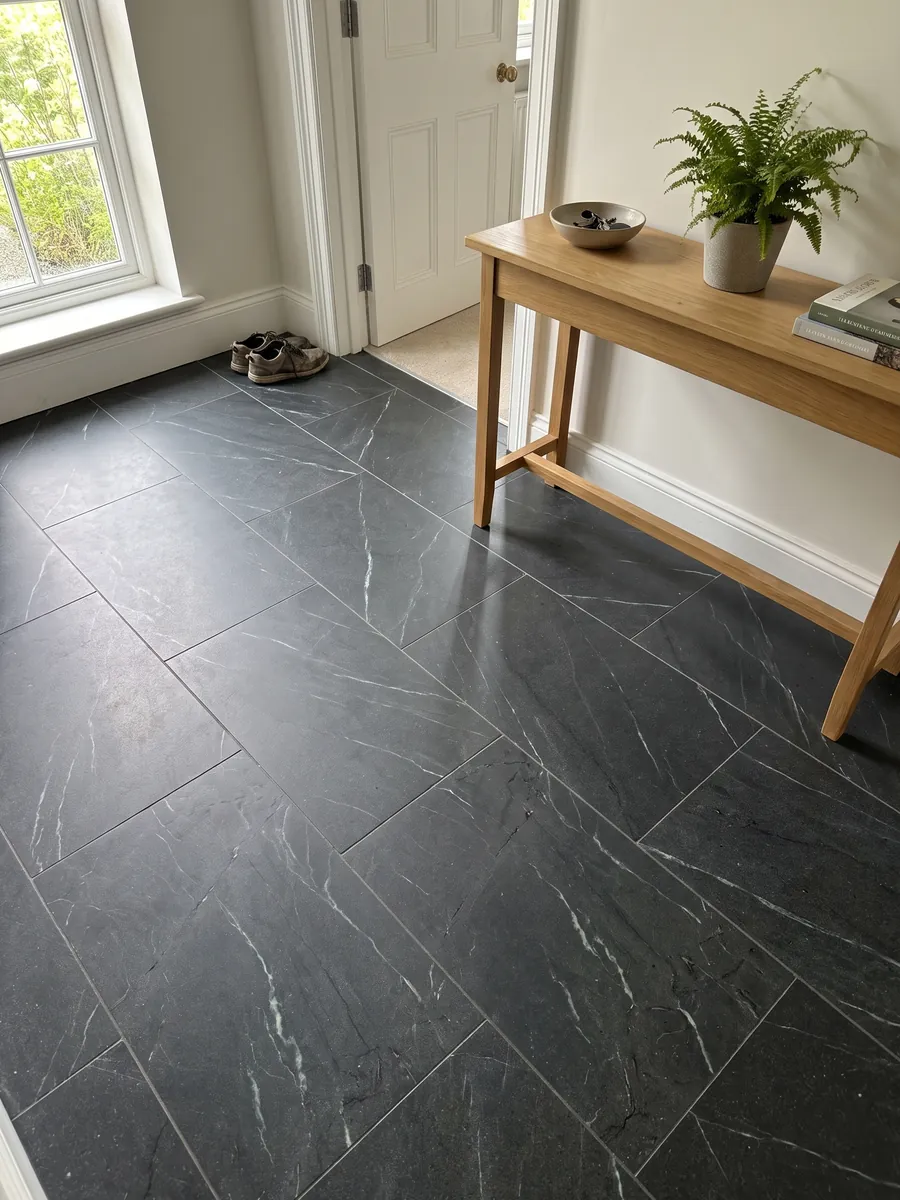 Piso de recibidor en placas grandes de cuarcita negra Negresco con luz natural: negro con vetas blancas finas y escasas en diagonal