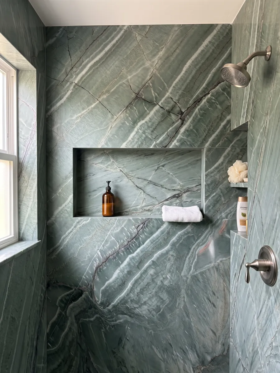 Ducha revestida con placas enteras de cuarcita verde Amazzonia Green con nicho empotrado: verde jade con ondas blancas diagonales y vetas oscuras que se cruzan