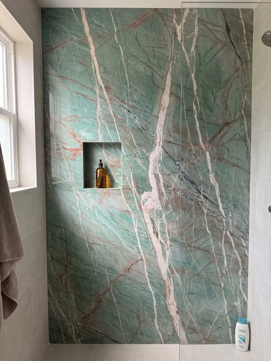 Ducha revestida con placas enteras de cuarcita verde Amazzonite Cristallo con nicho empotrado: verde azulado cruzado por vetas blancas rosadas y finas líneas rojizas