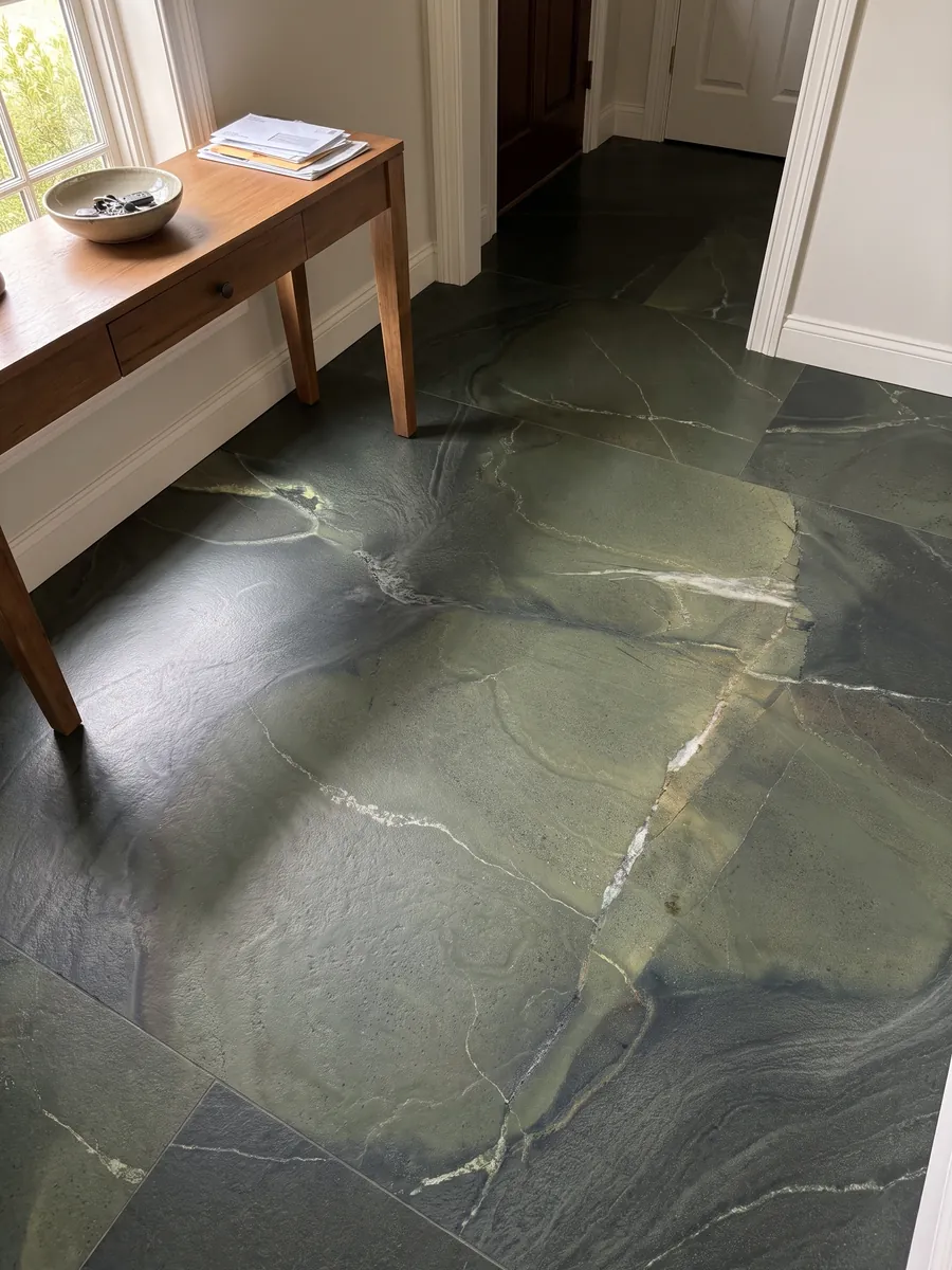 Piso de recibidor en placas grandes de cuarcita verde Avocatus con luz natural: verde profundo por zonas, cruzado por unas pocas líneas blancas finas