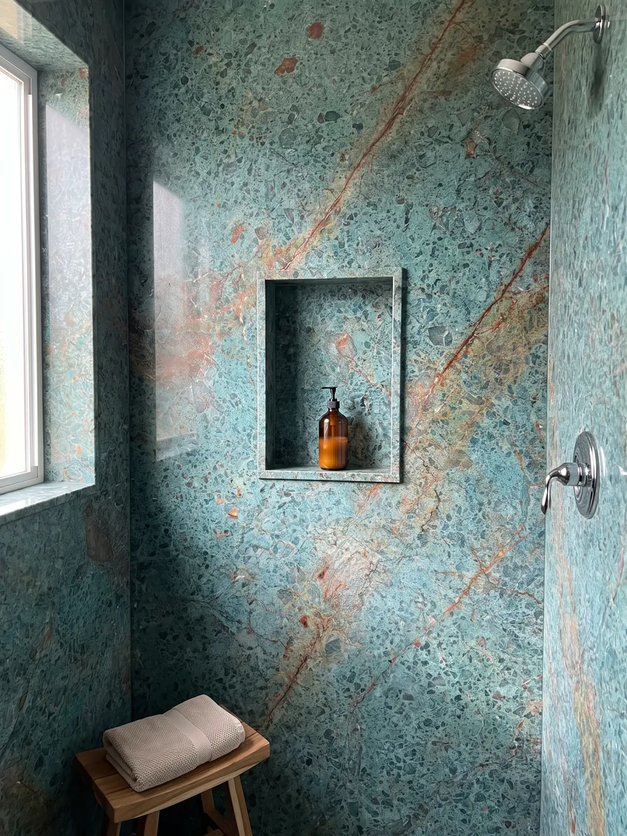 Ducha revestida con placas enteras de cuarcita verde Tanzanite con nicho empotrado: turquesa moteado cruzado por una banda diagonal rojo óxido