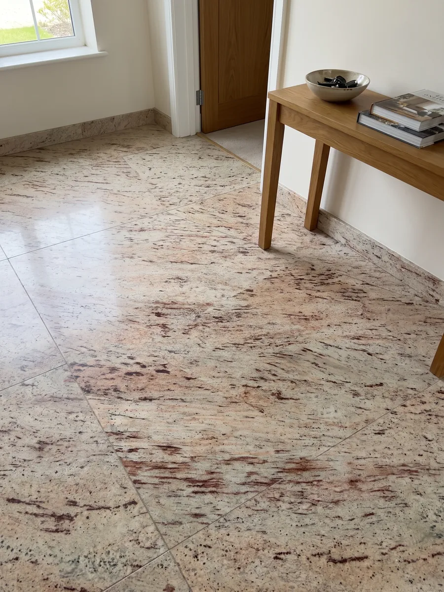 Piso de recibidor en placas grandes de granito beige Ivory Brown con luz natural: marfil con trazos horizontales rojizos y burdeos
