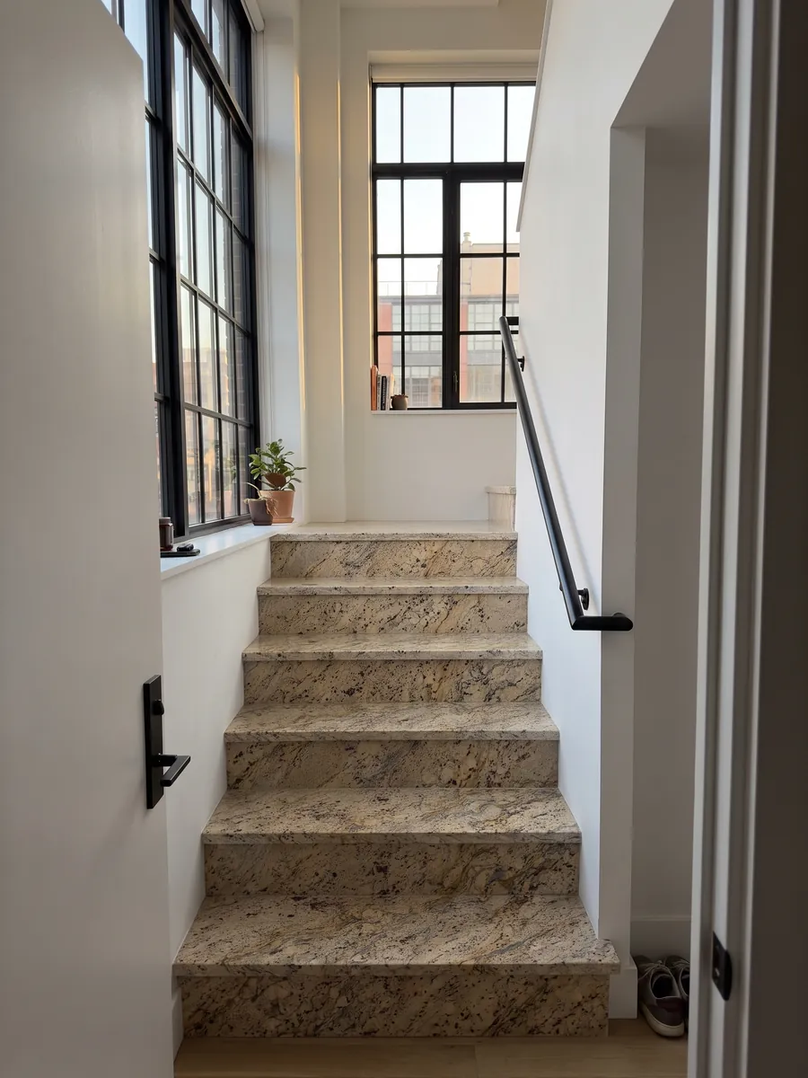 Escalera interior con peldaños de granito beige Santa Cecilia con pasamanos: beige dorado con manchas burdeos y vetas doradas y gris oscuro