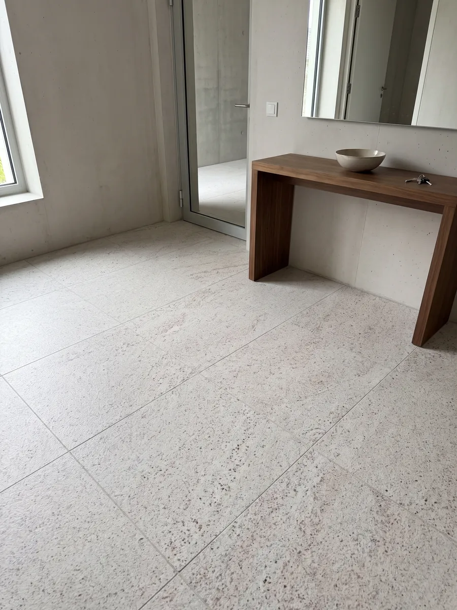 Piso de recibidor en placas grandes de granito blanco Branco Siena con luz natural: blanco con un moteado fino rosado y gris