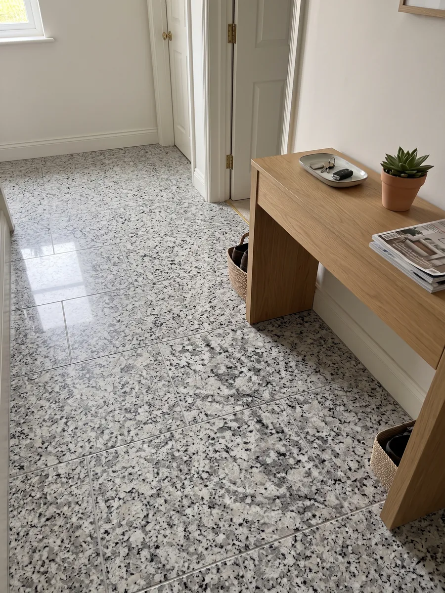 Piso de recibidor en placas grandes de granito blanco Sardo Bianco con luz natural: blanco de grano grueso con cristales grises y negros