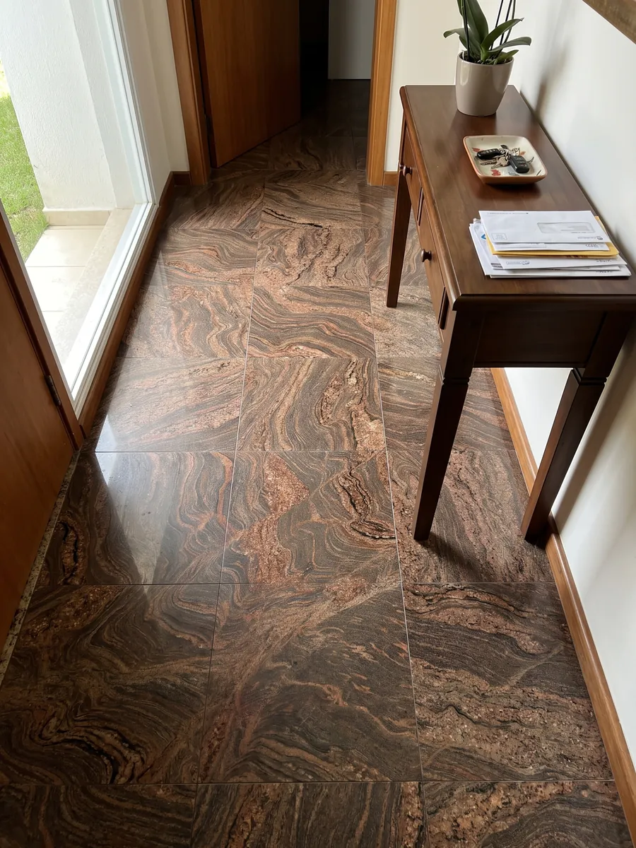 Piso de recibidor en placas grandes de granito café Juparana Dourado con luz natural: marrón ocre con ondas y remolinos rojizos muy movidos