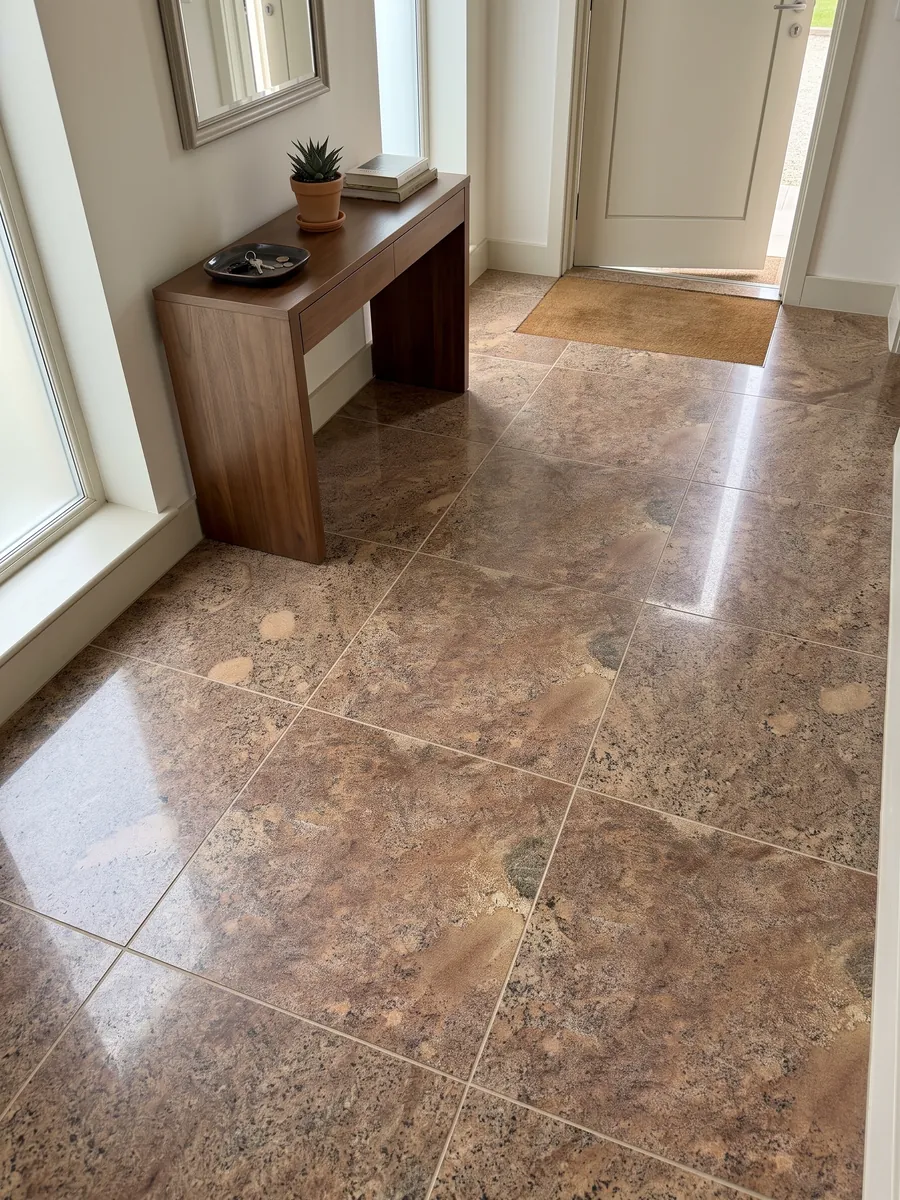 Piso de recibidor en placas grandes de granito café Juparana Florence con luz natural: marrón cobrizo granulado con zonas beige difusas