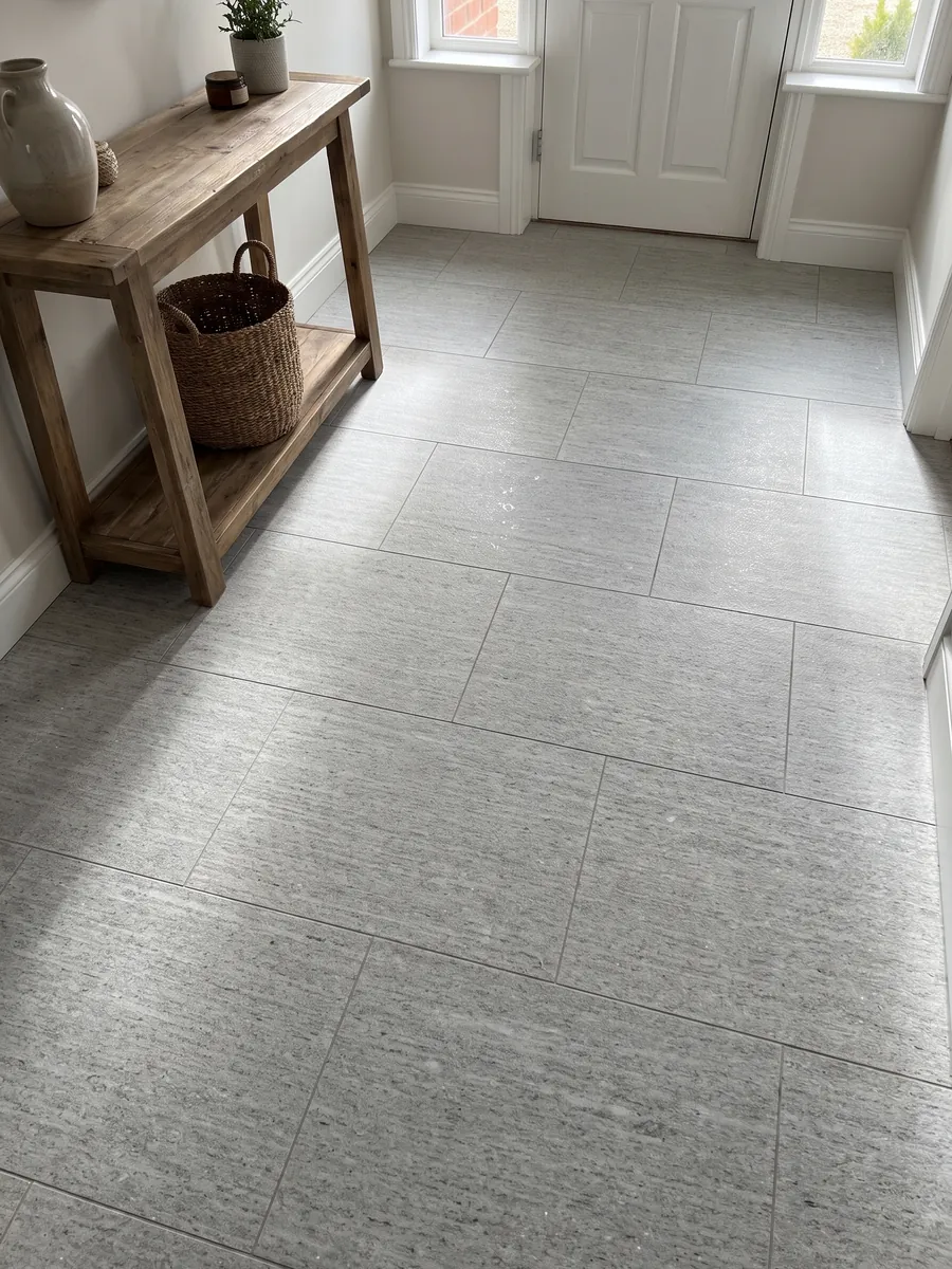 Piso de recibidor en placas grandes de granito gris Beola Bianca con luz natural: gris claro con rayado horizontal fino y pequeños brillos