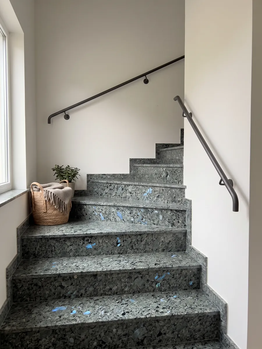 Escalera interior con peldaños de granito gris Labradorita con pasamanos: cristales grandes gris verdosos con destellos azules iridiscentes