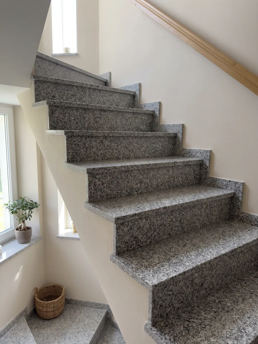 Escalera interior con peldaños de granito gris Sardo Grigio con pasamanos: gris claro sal y pimienta de grano medio