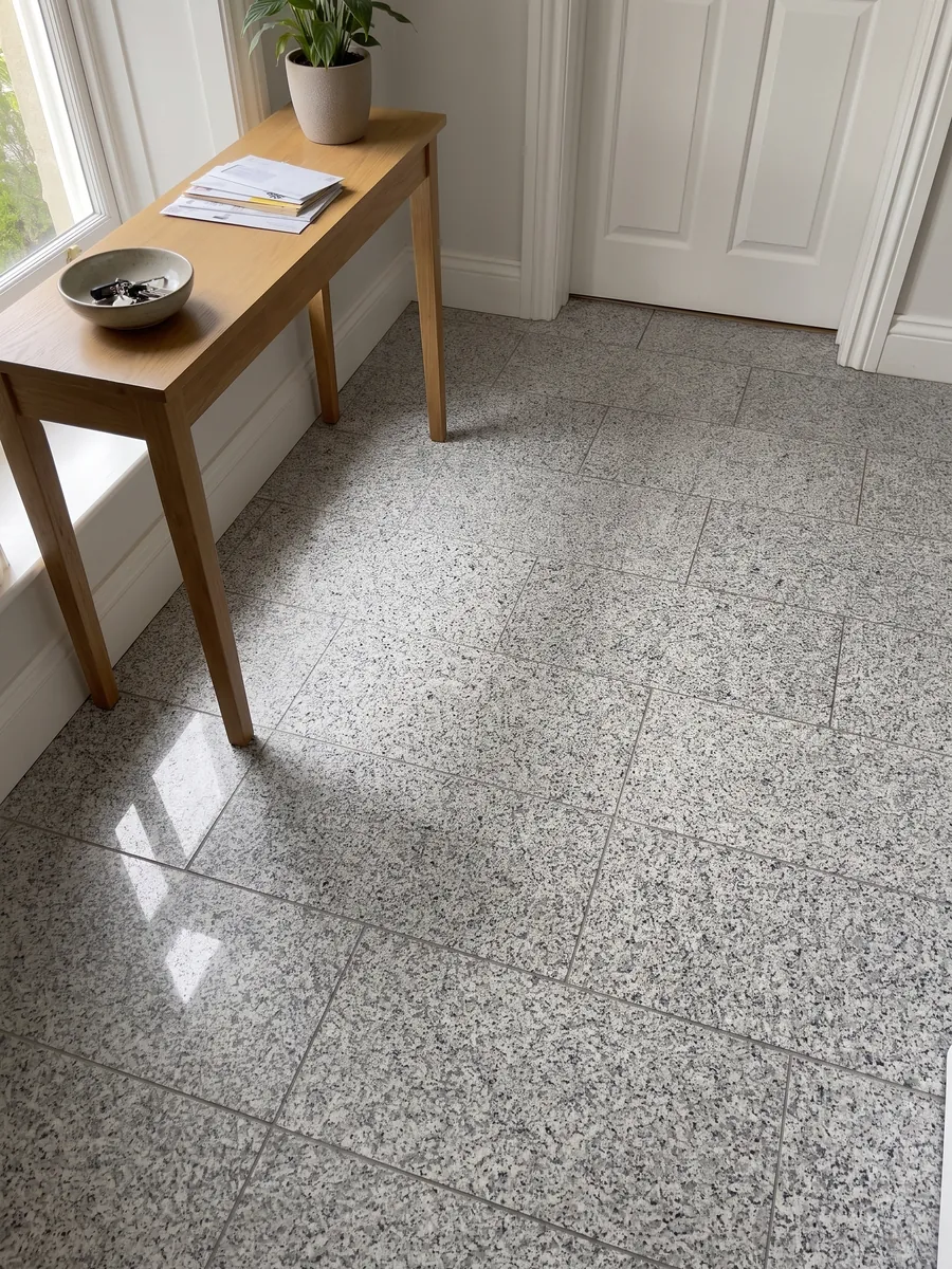 Piso de recibidor en placas grandes de granito gris Sardo Grigio con luz natural: gris claro sal y pimienta de grano medio