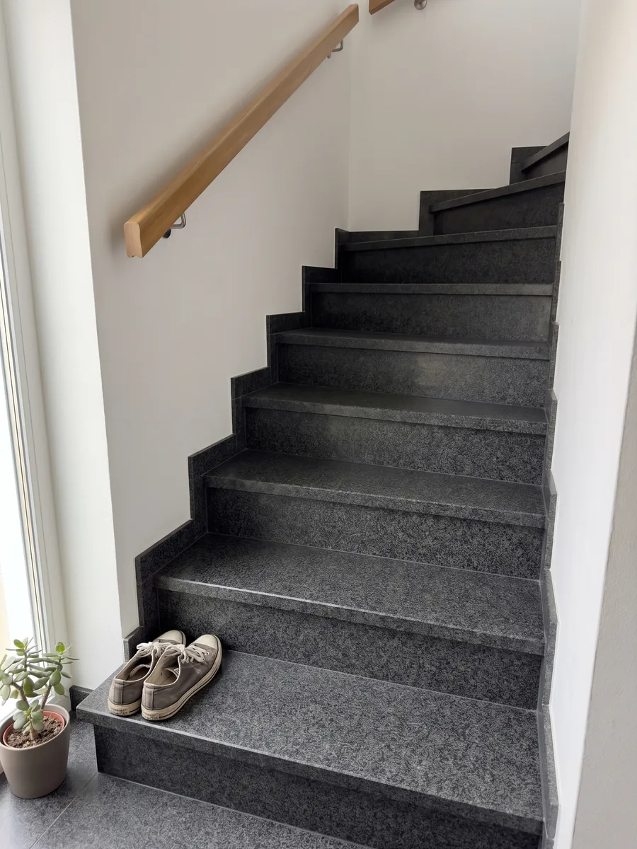 Escalera interior con peldaños de granito negro Nero Africa con pasamanos: negro de grano fino uniforme con leve punteado gris
