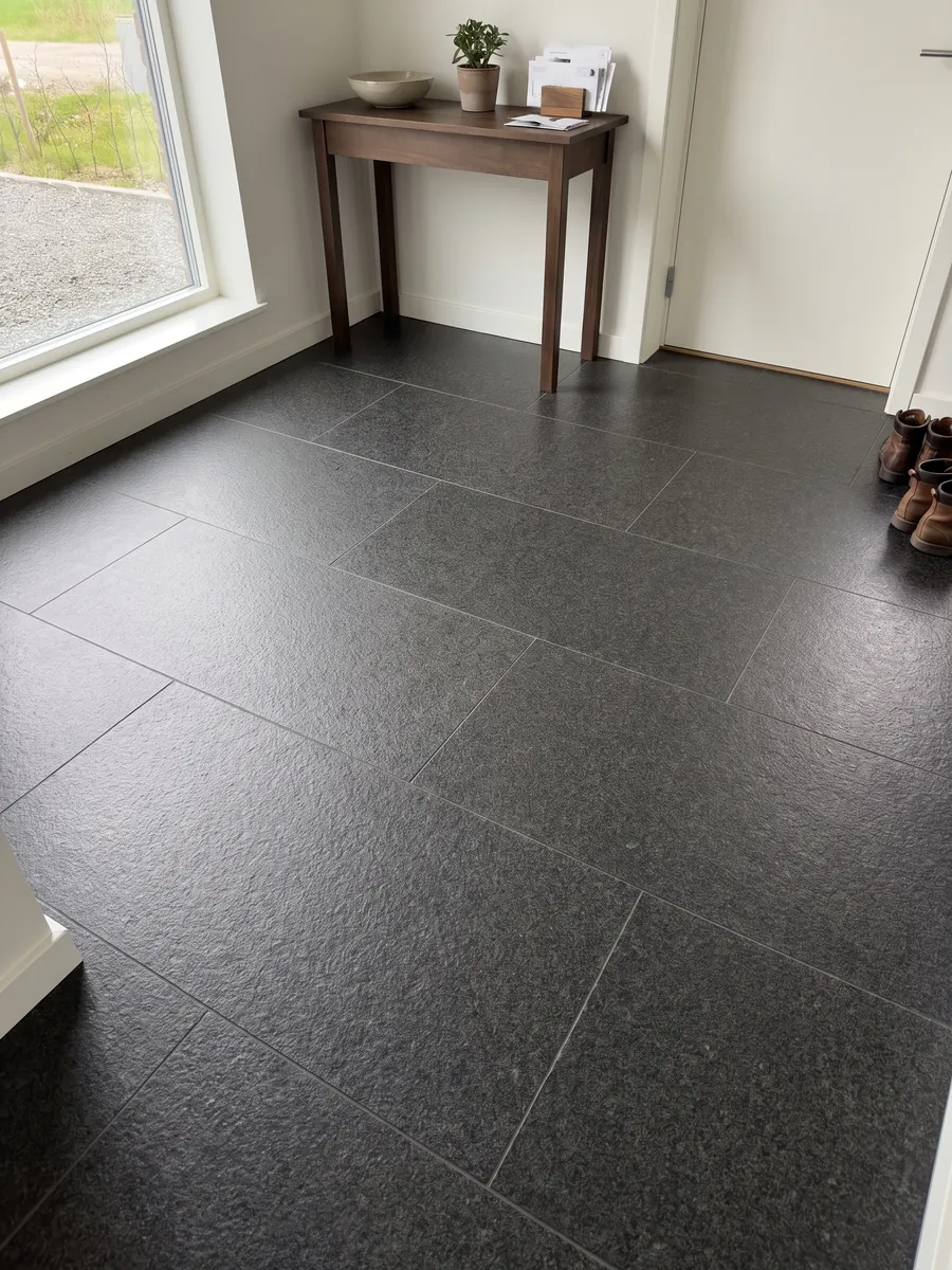 Piso de recibidor en placas grandes de granito negro Nero Africa con luz natural: negro de grano fino uniforme con leve punteado gris