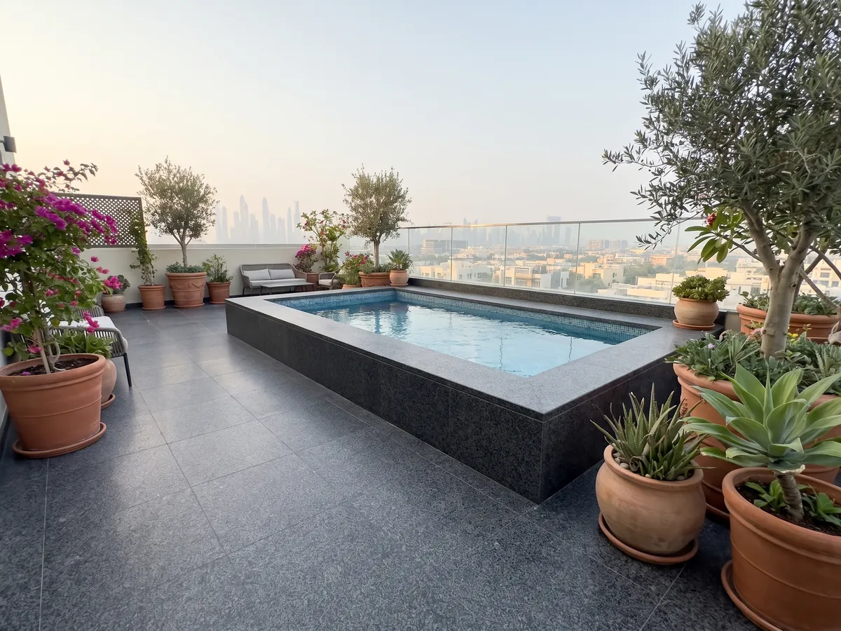 Piso de terraza y borde de piscina en granito negro Nero Africa con macetas: negro de grano fino uniforme con leve punteado gris