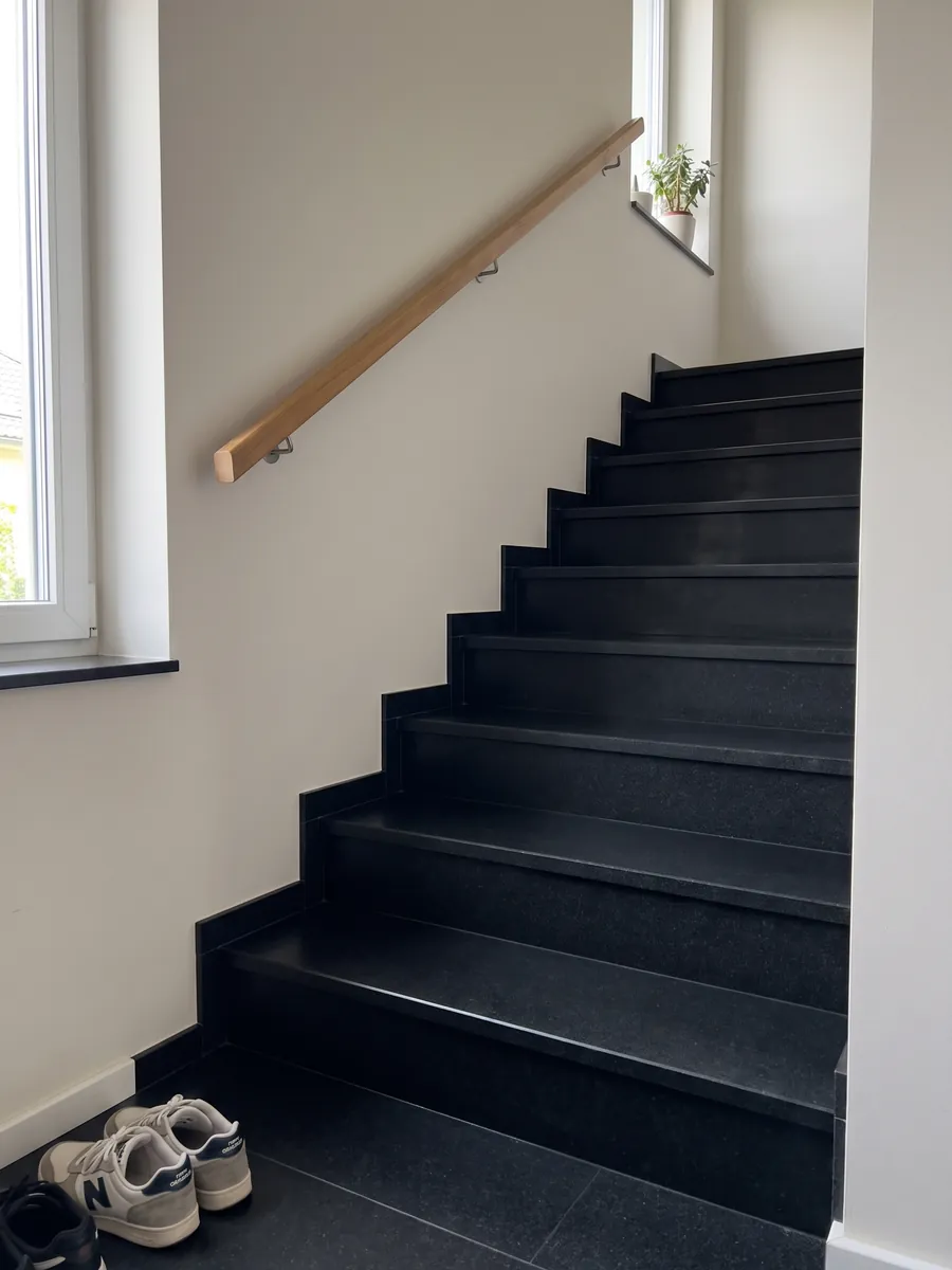 Escalera interior con peldaños de granito negro Nero Assoluto con pasamanos: negro uniforme sin dibujo