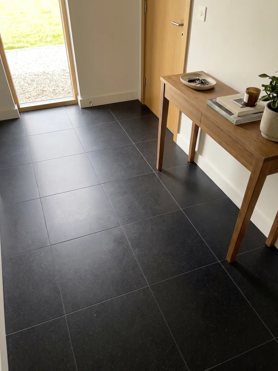 Piso de recibidor en placas grandes de granito negro Nero Assoluto con luz natural: negro uniforme sin dibujo