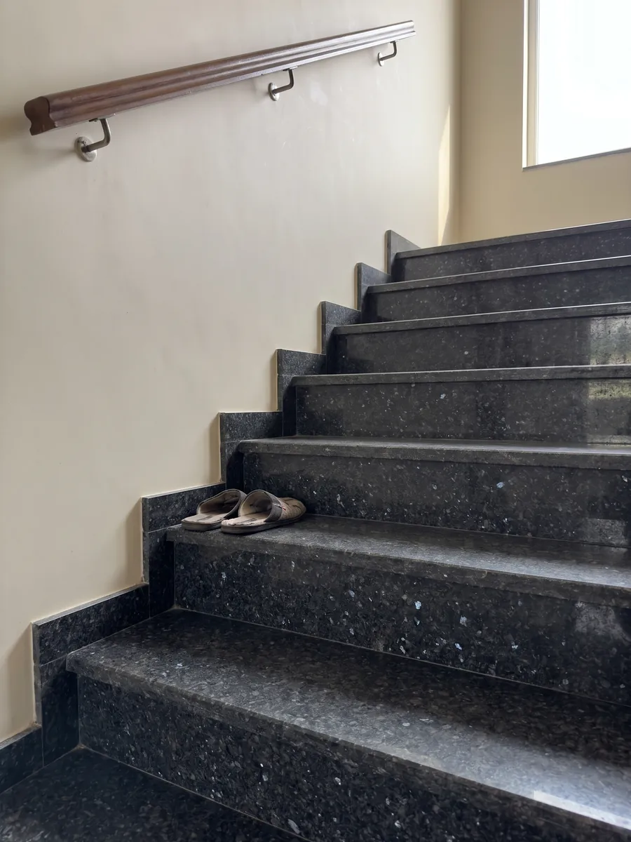 Escalera interior con peldaños de granito negro Stargate con pasamanos: gris antracita granulado con cristales grises y violáceos