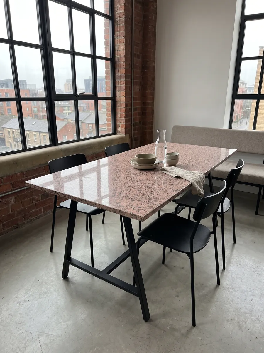 Mesa de comedor con cubierta de Granito Rosa de Salto sobre base de acero: rosado moteado con puntos gris oscuro y blancos