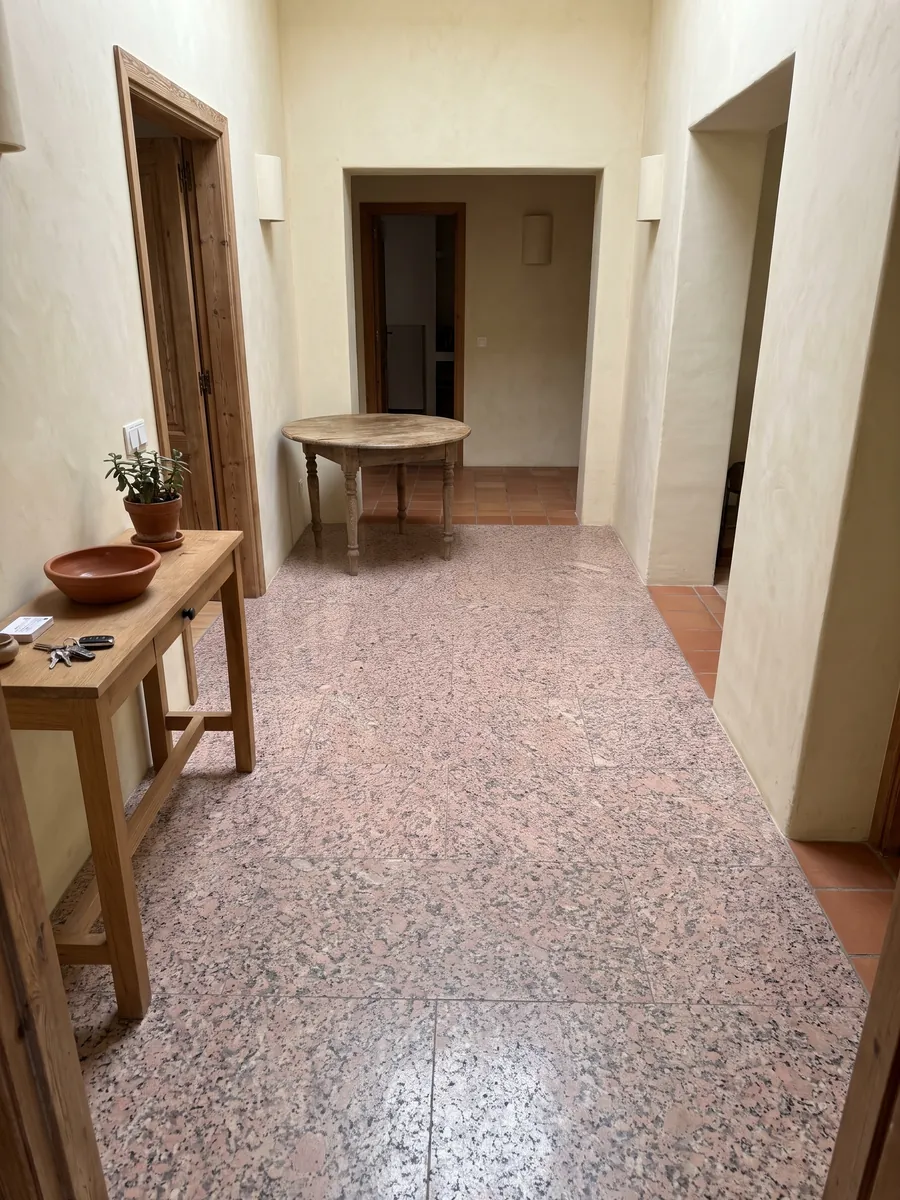 Piso de recibidor en placas grandes de Granito Rosa de Salto con luz natural: rosado moteado con puntos gris oscuro y blancos
