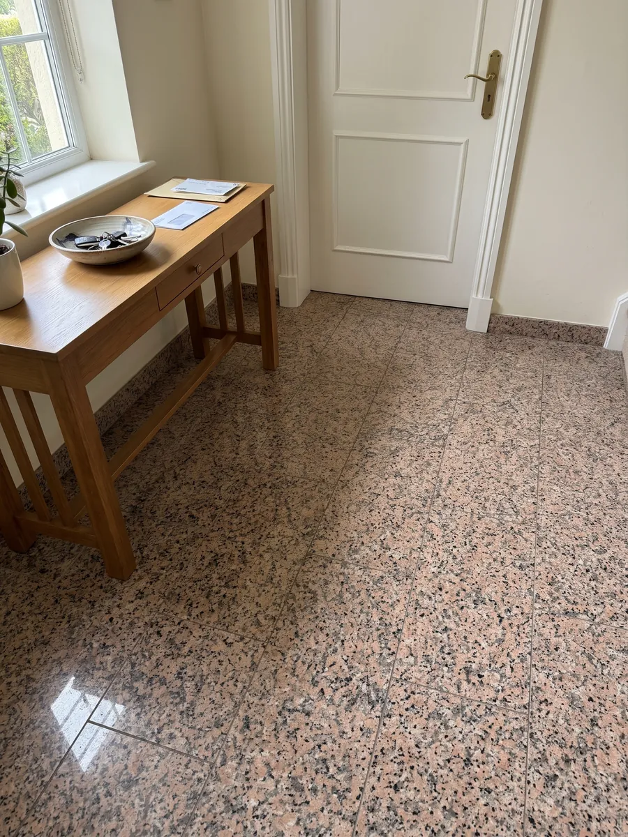 Piso de recibidor en placas grandes de Granito Rosa Porriño con luz natural: rosa salmón granulado con puntos negros