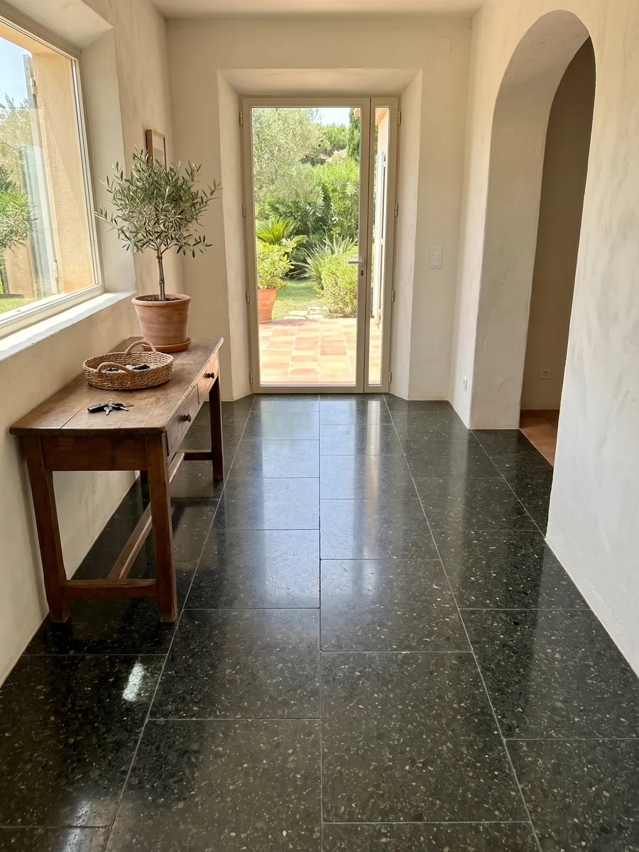 Piso de recibidor en placas grandes de Granito Verde Ubatuba con luz natural: verde casi negro con destellos de verde claro y dorado