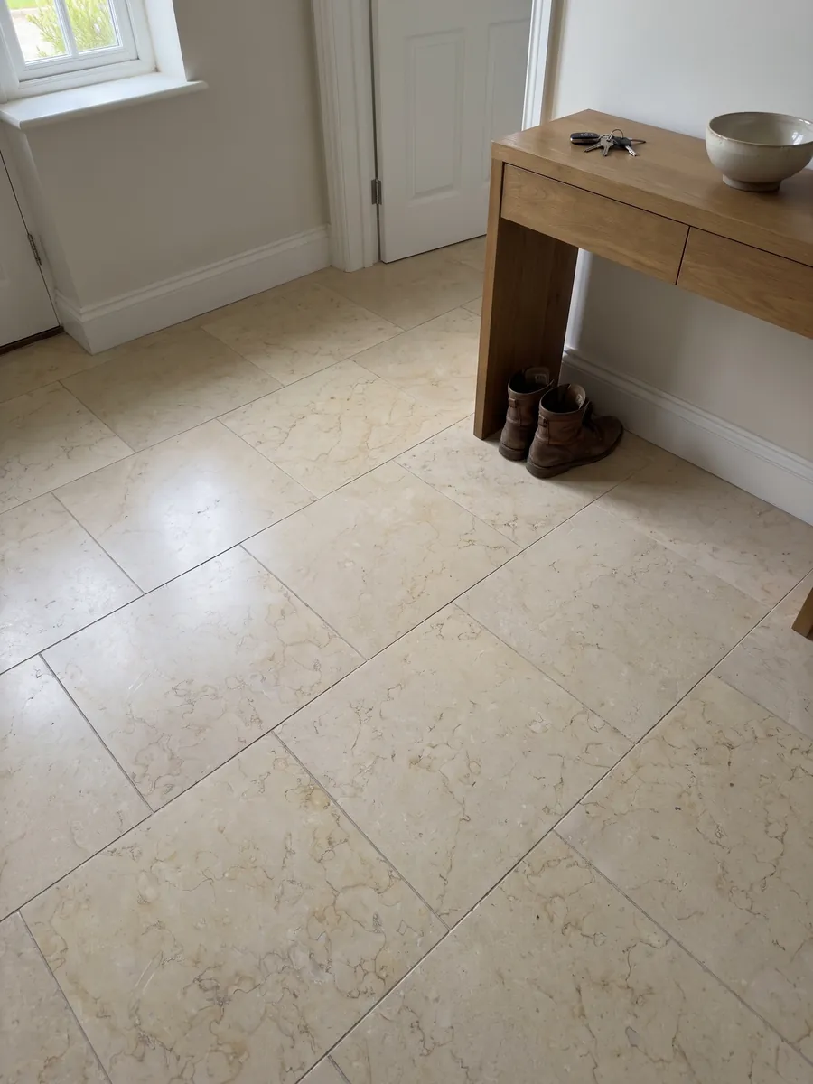 Piso de recibidor en placas grandes de Mármol Amarillo Silvia Oro con luz natural: amarillo pálido muy uniforme con un dibujo fino de líneas claras apenas visible