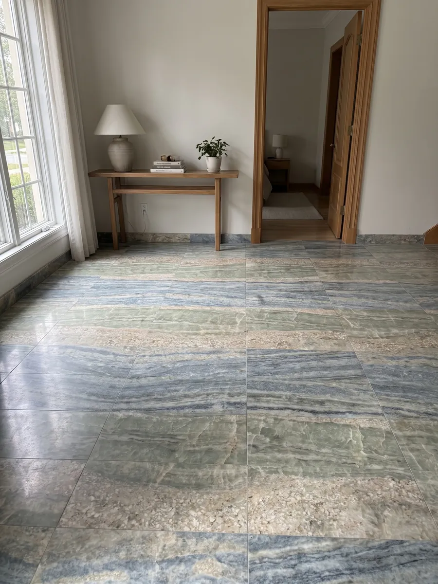 Piso de recibidor en placas grandes de mármol azul Calcite Caraibica con luz natural: bandas horizontales de cristales gris azulado, verde salvia y beige