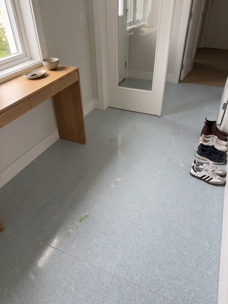 Piso de recibidor en placas grandes de Mármol Azul Cielo con luz natural: celeste pálido casi uniforme de grano fino, con una inclusión verde a la izquierda