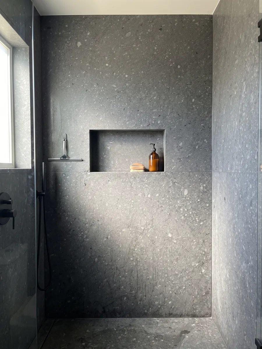 Ducha revestida con placas enteras de Mármol Azul Masaccio con nicho empotrado: gris oscuro uniforme con pequeñas motas y fragmentos grises más claros
