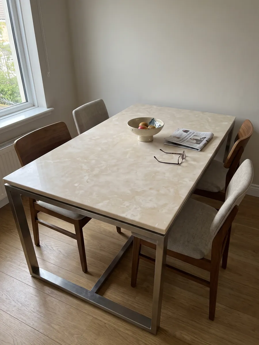 Mesa de comedor con cubierta de mármol beige Botticino sobre base de acero: crema cálido casi uniforme con nubes suaves
