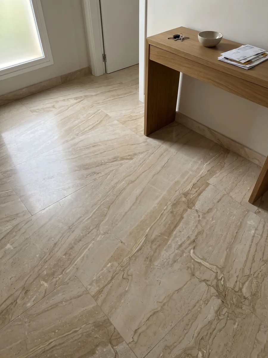 Piso de recibidor en placas grandes de mármol beige Breccia Sarda con luz natural: beige cálido con vetas crema y marrón claro en diagonal