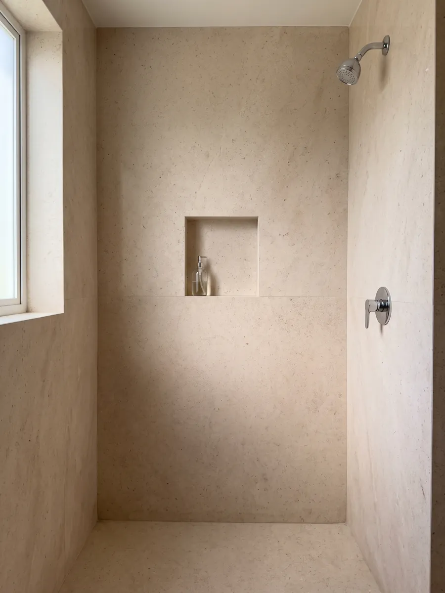 Ducha revestida con placas enteras de mármol beige Masai con nicho empotrado: crema rosado claro y parejo, de grano fino sin vetas