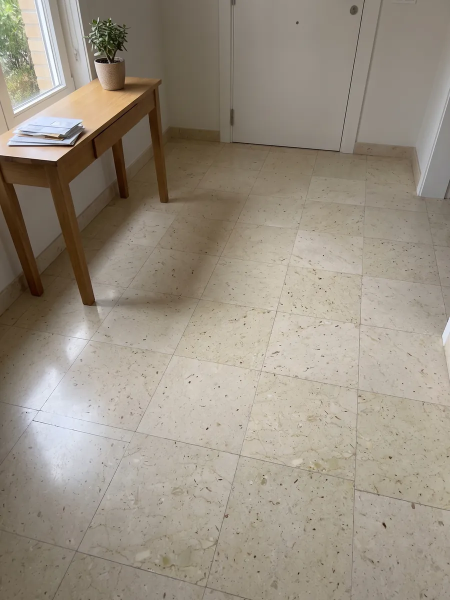 Piso de recibidor en placas grandes de mármol beige Pietra Ducale con luz natural: crema amarillento con pequeños fragmentos fósiles y puntitos marrones