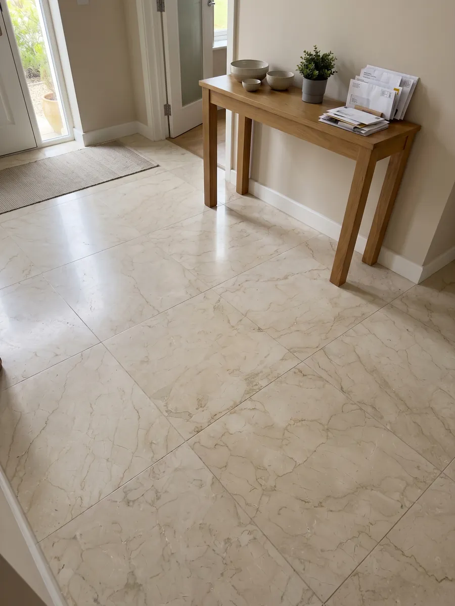 Piso de recibidor en placas grandes de mármol beige Pietra Orsera con luz natural: crema claro con una red de vetas beige muy tenues