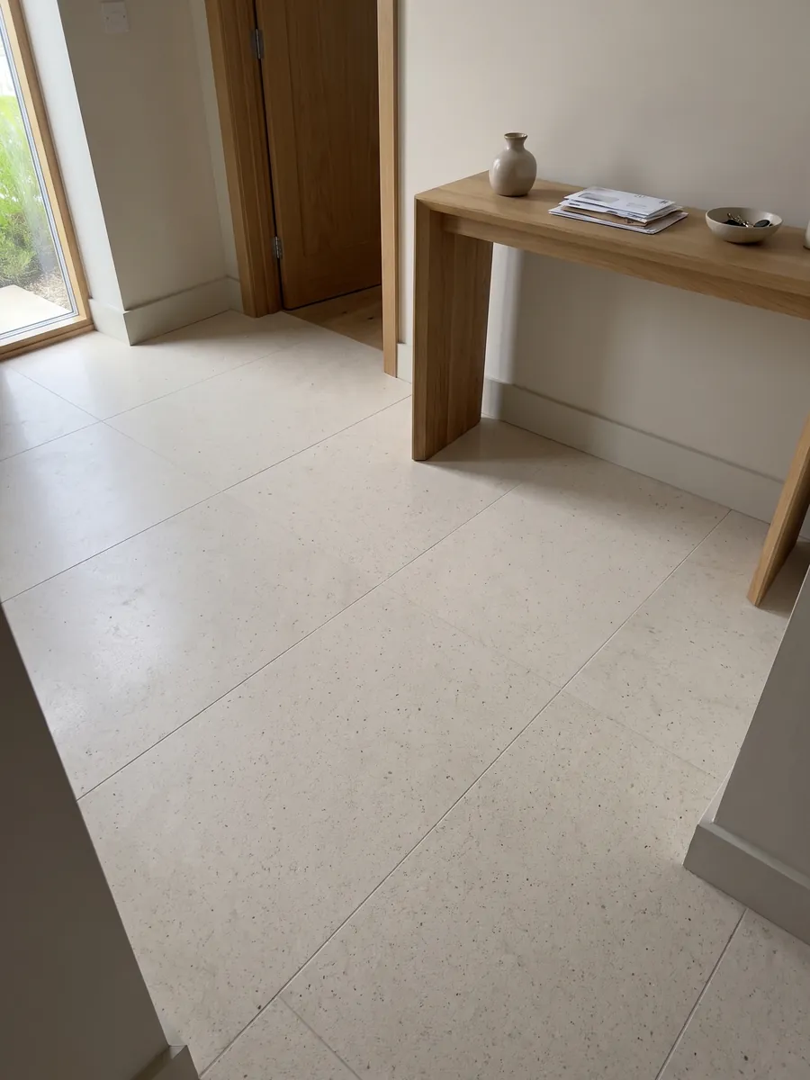 Piso de recibidor en placas grandes de mármol beige Veselje con luz natural: crema liso y homogéneo, con puntitos oscuros apenas visibles